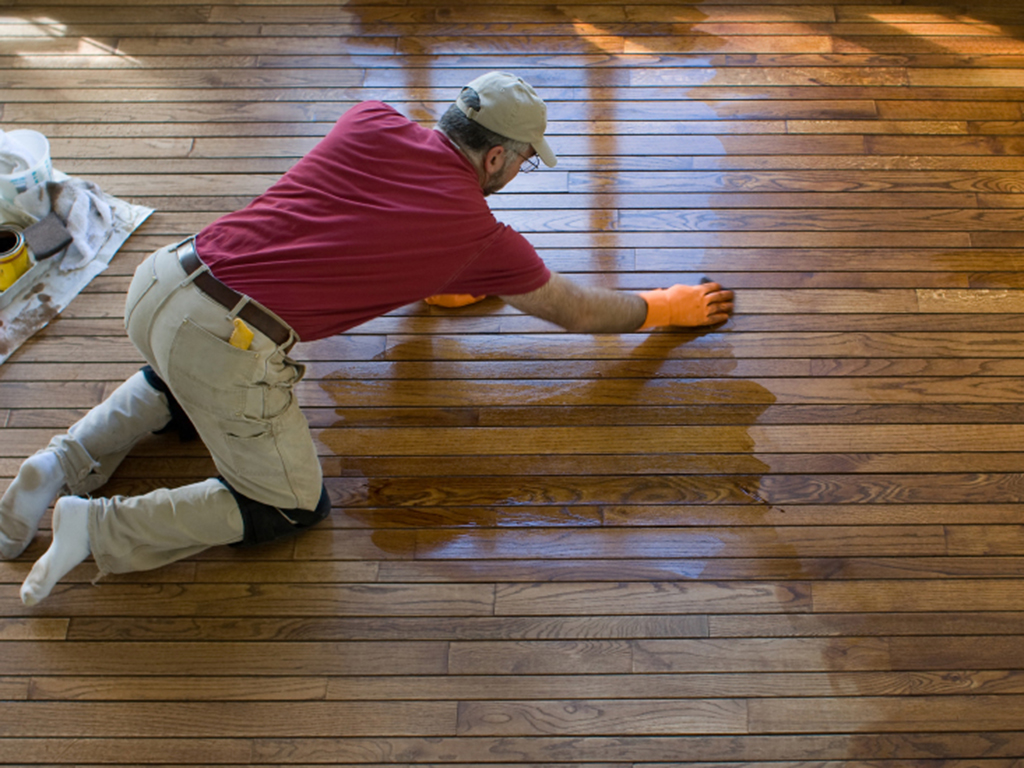 a white house, tn floor refinisher hard at work updating a wood floor.