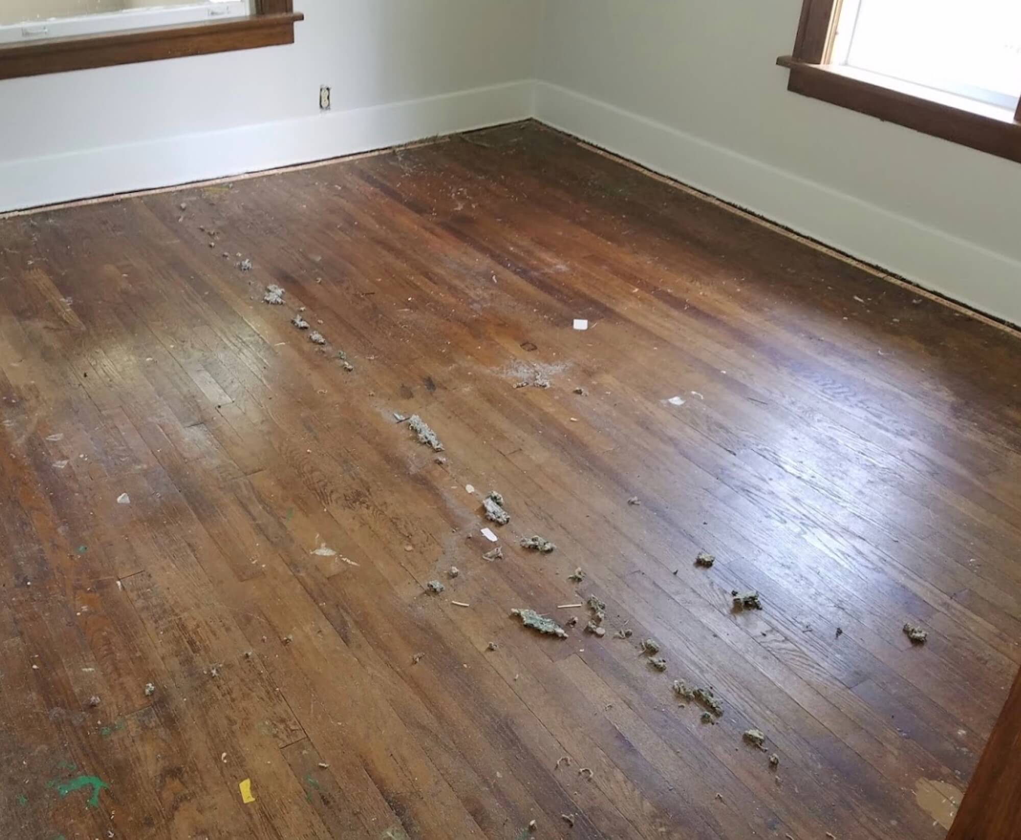 a dusty and damaged old hardwood floor
